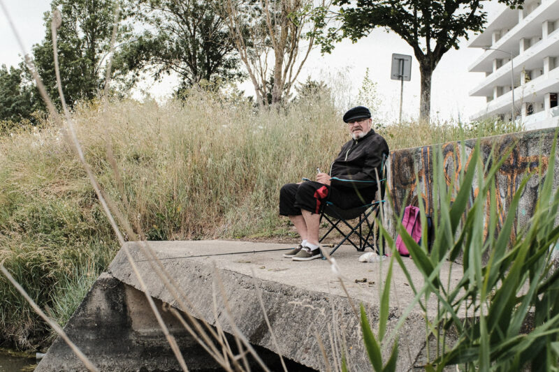 Um pescador à beira do canal Marans em La Rochelle